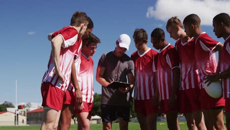 coach talking to rugby players on the field