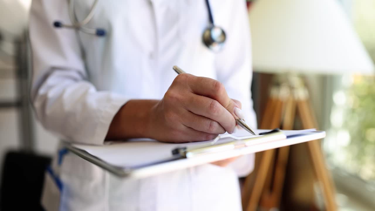 Doctor escribiendo en un portapapeles