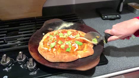 slicing a homemade taco pizza