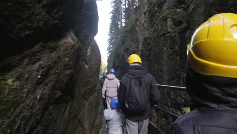 a group of tourists in protective helmets walks through a mountain canyon group travel concept a group of tourists in protective helmets walks through a mountain canyon group travel concept