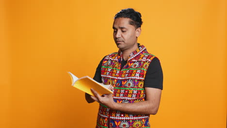 Man-reading-book,-having-fun,-isolated-over-studio-background