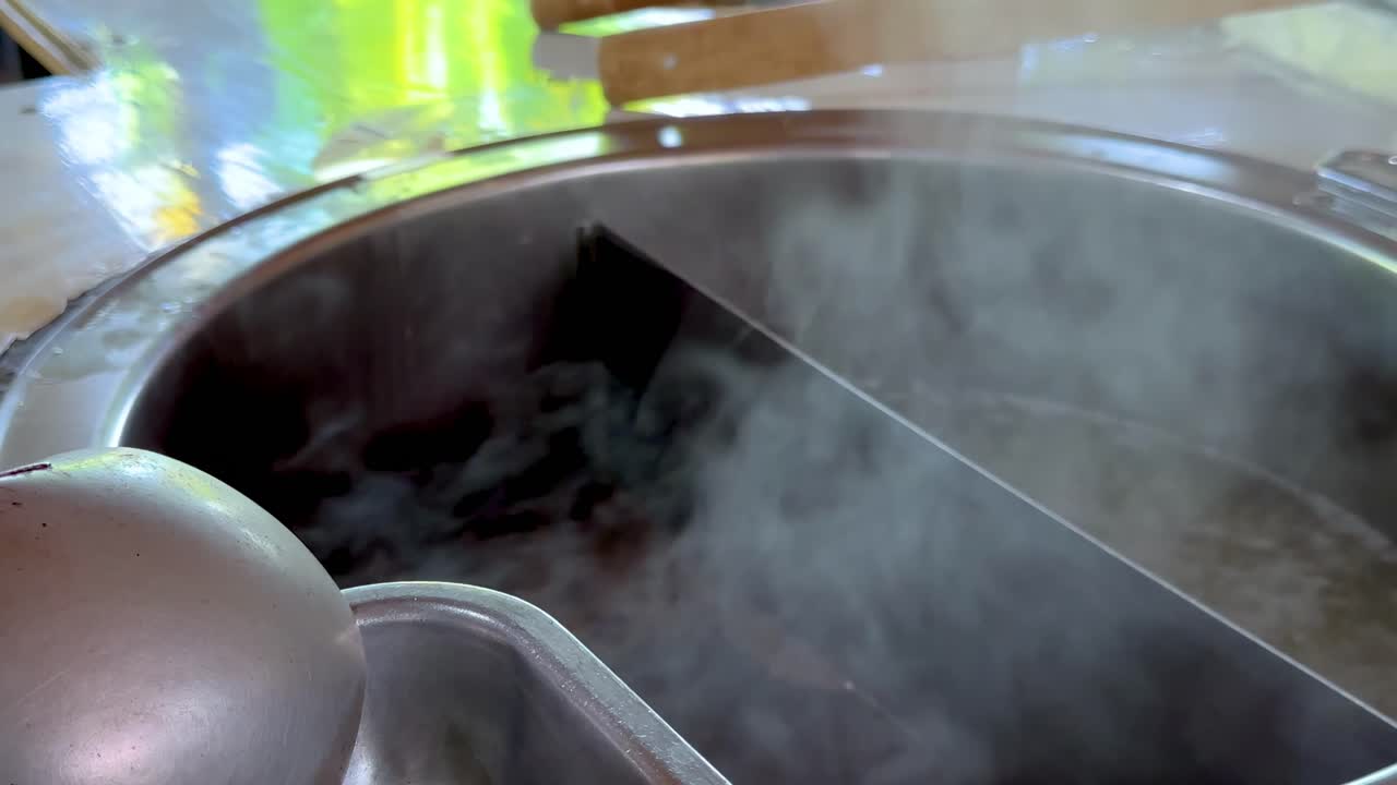 Close-up of steam billowing from a sectioned pot, highlighting the cooking process.