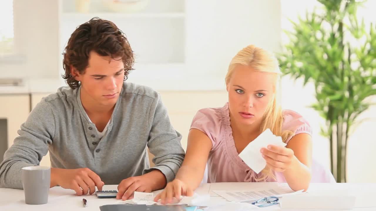 Worried couple checking at their expenses