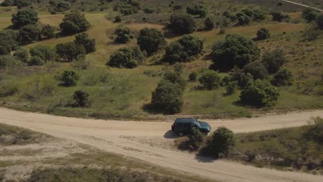 Toma-Aérea-De-Un-Vehículo-4x4-Girando-A-La-Izquierda-En-Una-Bifurcación