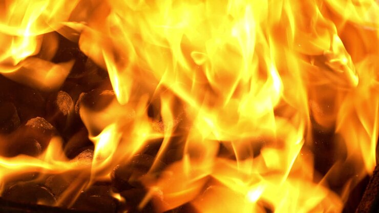 Primo piano del fuoco al rallentatore in un affumicatore offset (BBQ pit)