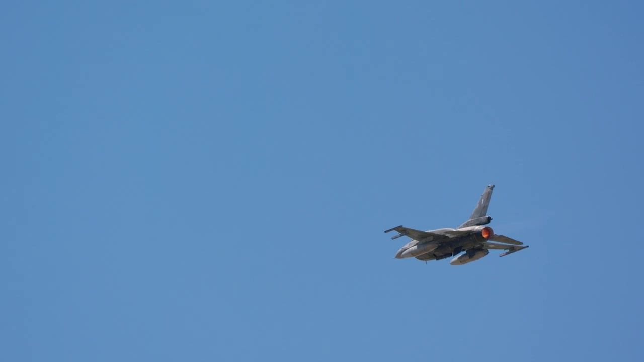 Combat jet climbing away with afterburner glow
