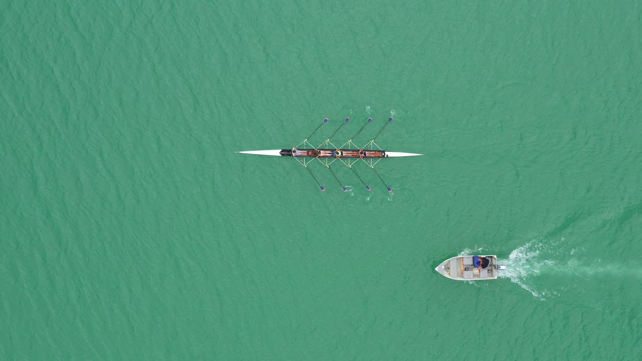 보트 호수 에 있는 코치 와 함께 로잉 팀 의 공중 위상 훈련 을 이어가고 있다