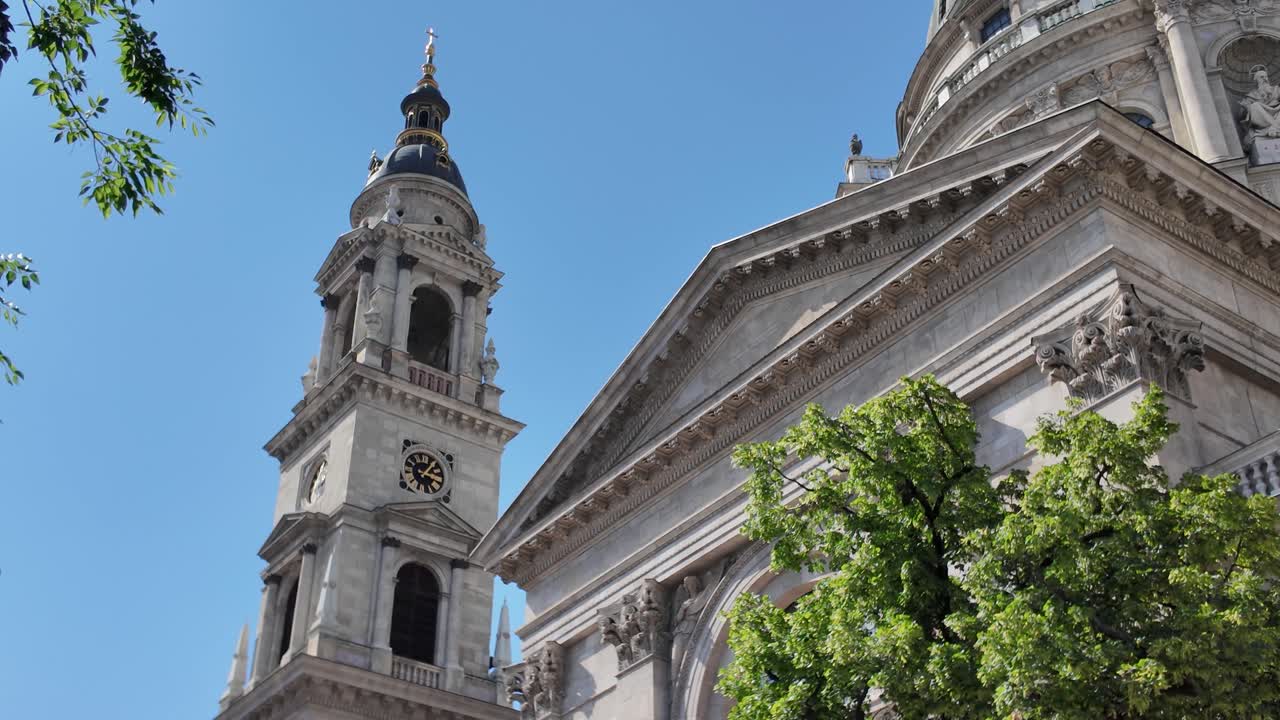 Majestic dome and towers of St. Stephen’s Basilica in Budapest, elegantly framed by surrounding trees