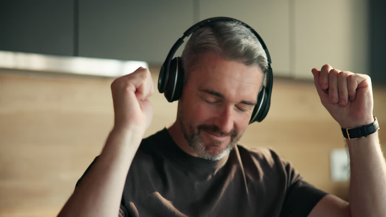 Uomo felice che ascolta musica con le cuffie a casa