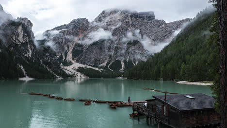 Kleine-Touristenboote-Schwimmen-Auf-Dem-Pragser-Wildsee.-Zeitraffer-Mit-Nebel,-Der-Um-Das-Alpine-Gebirgstal-Der-Dolomiten-Kriecht