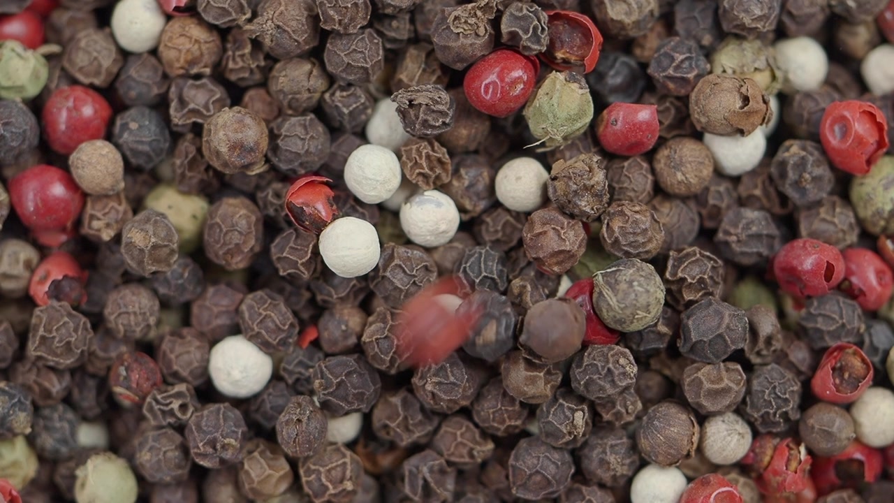 Close-up of Colorful Peppercorns Falling and Mixing