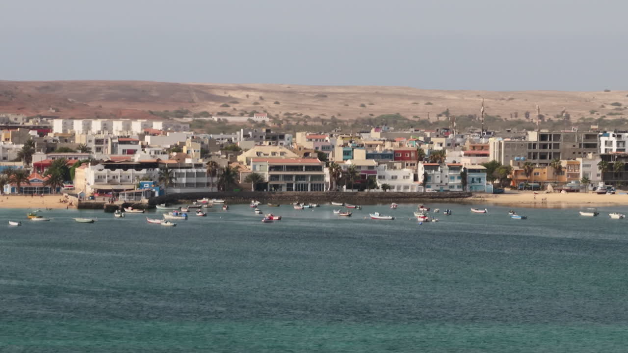 Nice close up view of the city of Sal Rei, luxury yachts and fishermen boats moored in the port, Old city with many colorful house,background the desert,Boa Vista, Cape Verde