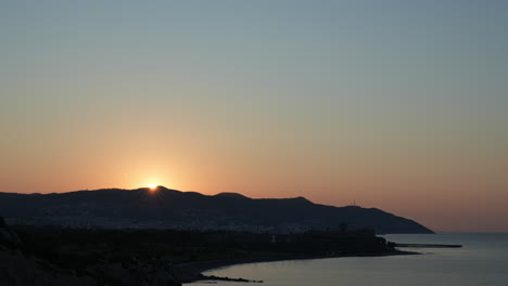 Spectacular-Time-Lapse-of-golden-sun-rise-over-the-majestic-mountain-ridge-near-the-picturesque-coastal-city