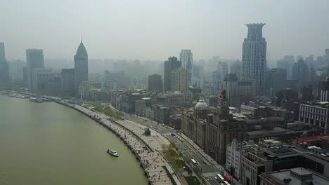 aerial tilt to busy river waterfront in the bund district of shanghai