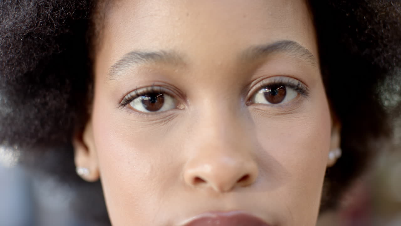 Close-up of african american woman looking ahead with focused expression in casual business setting