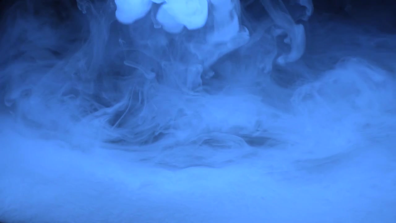 Nuvola di fumo blu su sfondo scuro.