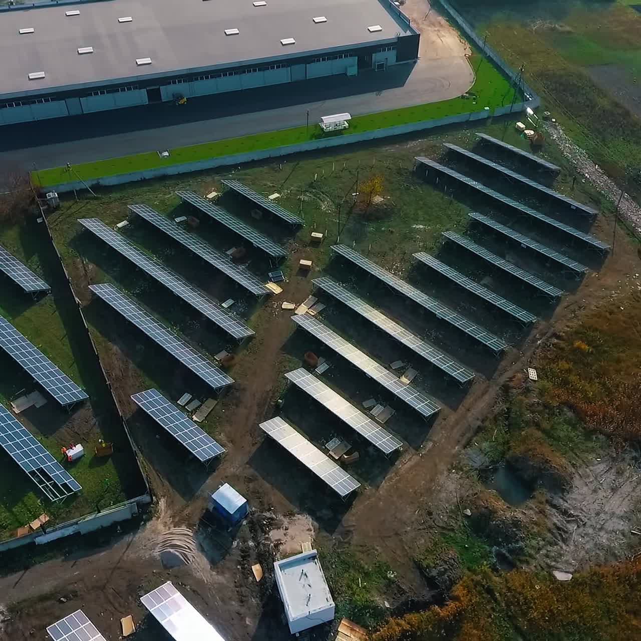 Small solar farm in rural place. Solar panels on field at sunlight. Production of cleen energy. Photovoltaic panels get sunny energy. Aerial view