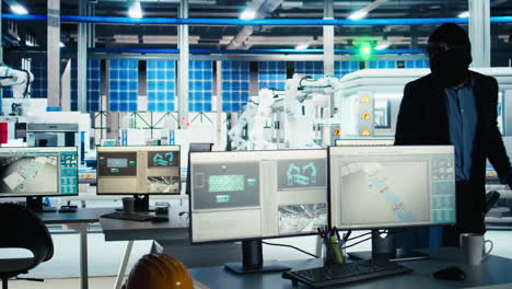 gemaskerde werknemer in een fotovoltaïsche fabriek die eigendomsrechtelijke technologie gegevens steelt