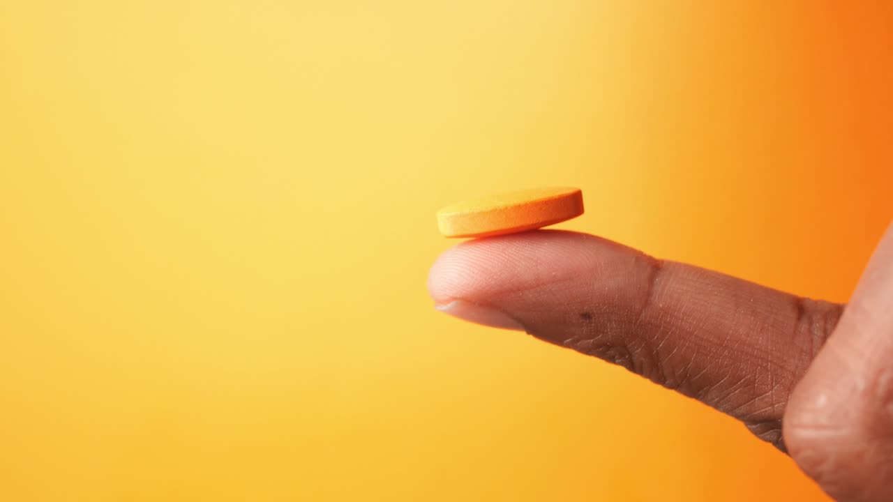 Orange Pill on Finger