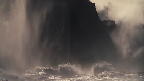 Huge-ocean-waves-roll-into-a-rocky-shore-in-slow-motion