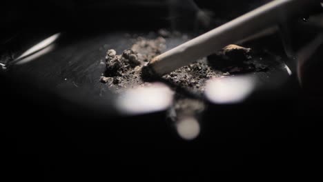 close up smoking cigarette on man hand.black ashtray. scene b