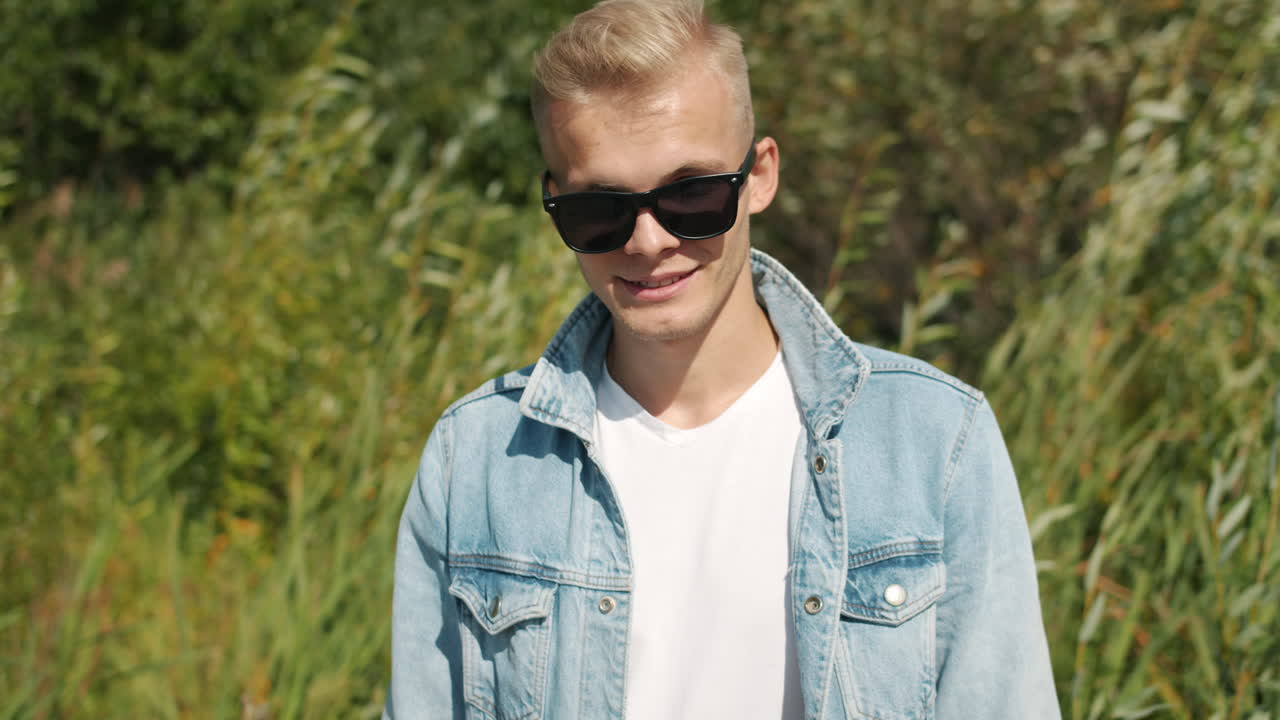 Young Man in Jeans Jacket and Sunglasses