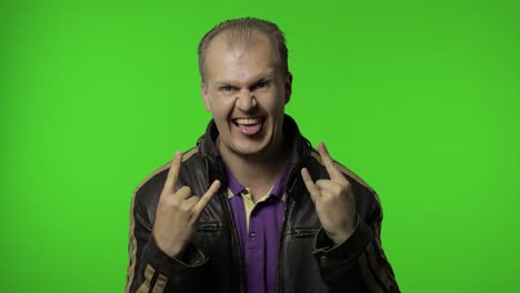 el hombre rocker mostrando el signo del rock and roll, el gesto de los cuernos del diablo, mirando con una expresión loca