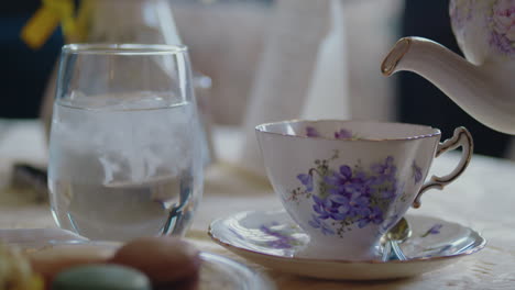 La-Tetera-Se-Vierte-En-La-Taza-De-Té-En-Un-Hermoso-Comedor-Iluminado-Por-Una-Ventana