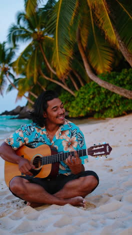 man playing guitar on a tropical beach at sunset