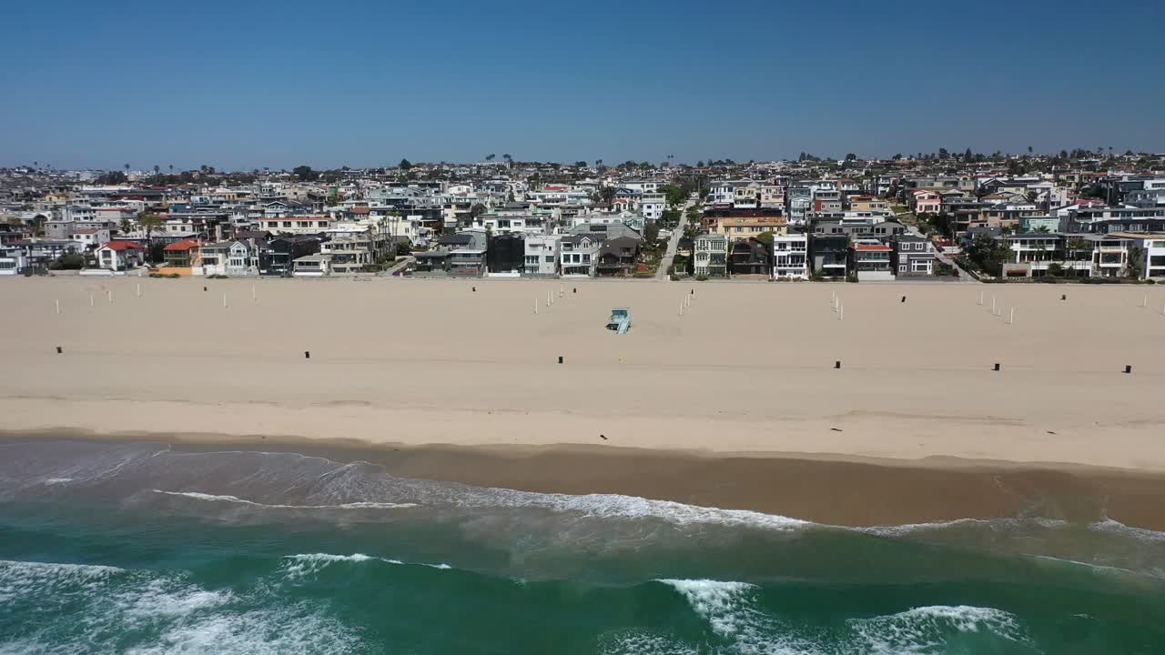 Turquoise Beach Of Manhattan Beach City With Cars Driving On Sandy Shore In California, USA. Aerial Slide Shot