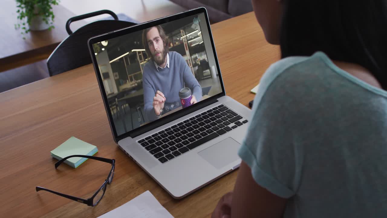 Mid section of african american woman having a video call with male colleague on laptop