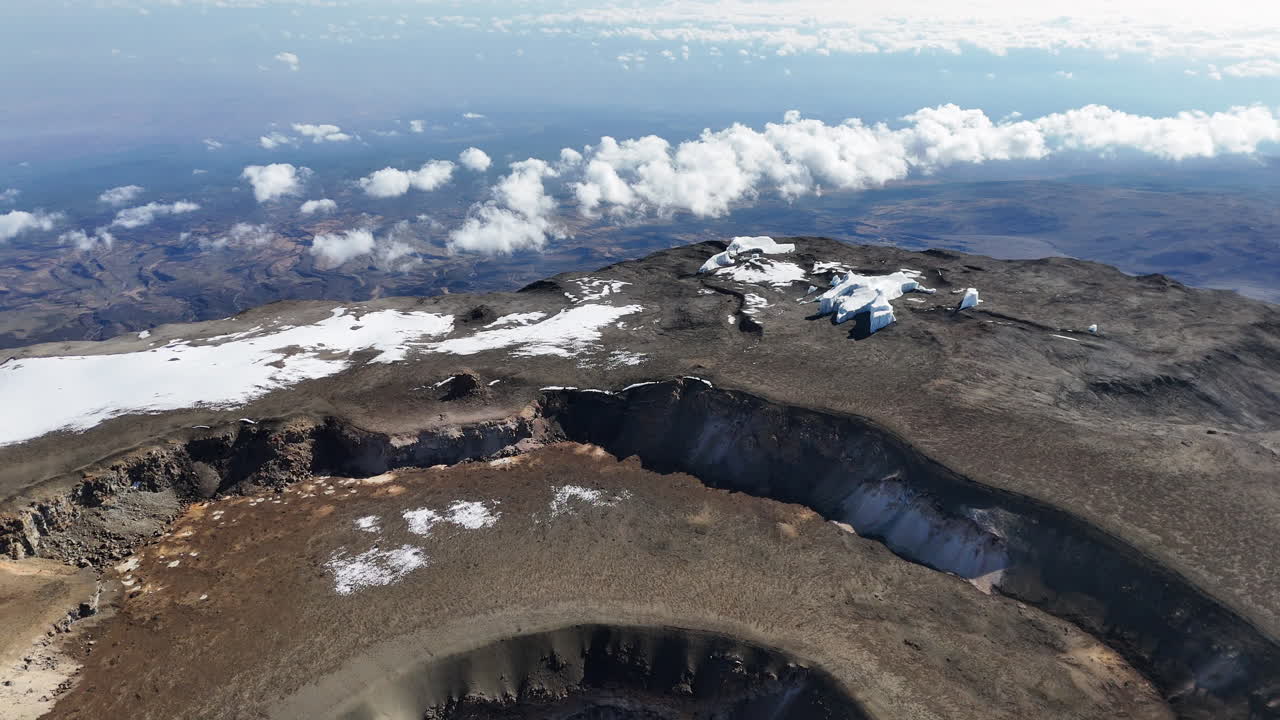 키리만자로 산의 우루루 피크와 그 아래의 화산 분화구의 드론 촬영. 천천히 드러나는 공중 촬영