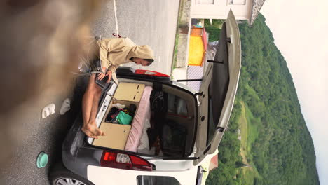 vertical digital nomad vanlife work remotely from his laptop with mountains forest landscape