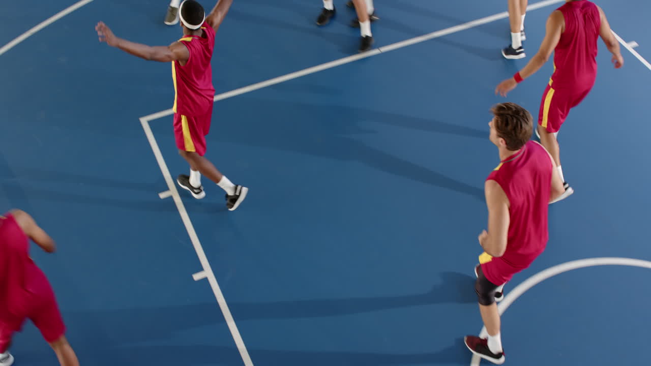 Players competing intensely on basketball court, focusing on making shot