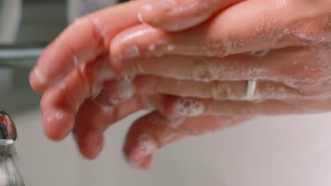 hands rubbing in circular motion with soap bubbles over skin to remove potential germs to keep skin clean and healthy