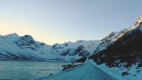 Road-covered-in-frost-snow-and-ice-near-a-lake-in-a-mountain-in-a-northern-country