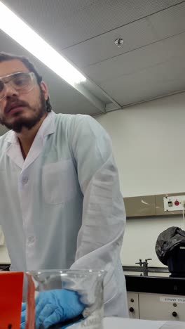 a man in protective lab attire holds documents