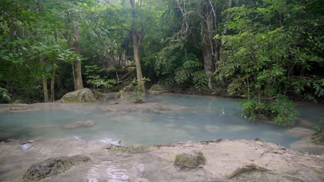 Slow-Motion-Panning-Left-to-Right,-Blue-Water-Pond-Surrounded-by-Trees