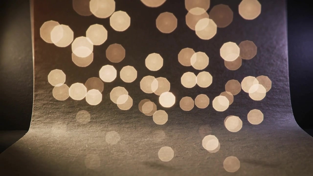 Shifting camera focus causing soft warm bokeh lights revealing textured paper roll backdrop