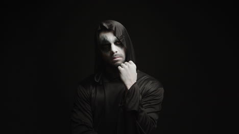 thoughtful scary grim reaper over black background