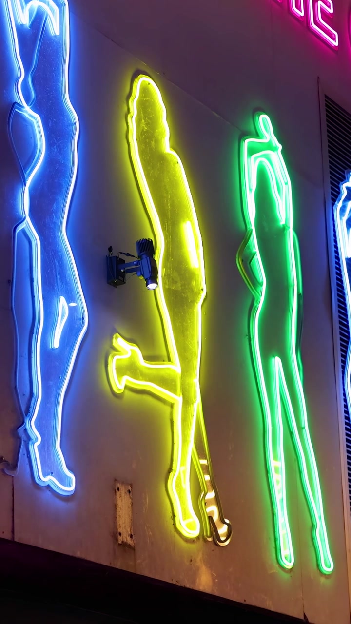 Sagome al neon illuminano una strada vivace a Phuket, Thailandia. Colori vivaci e illuminazione dinamica creano un'atmosfera notturna energica