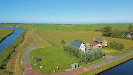 Annäherung-An-Einen-Traditionellen-Holländischen-Bauernhof-In-Der-Polderlandschaft-Mit-Kanälen-Durch-Eine-Absteigende-Drohne