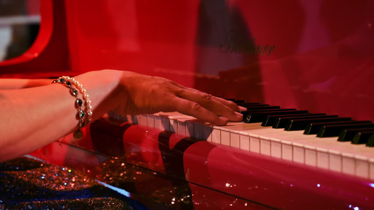 Close-up of an elderly woman playing a red piano