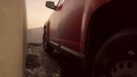 Low-level-view-of-red-SUV-in-icy-mall-parking-lot-in-winter