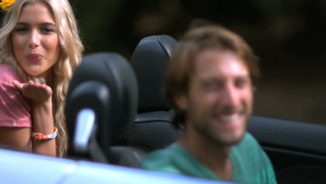 Chicas-Mandando-Besos-Mientras-Un-Amigo-Se-Ríe-En-El-Auto.