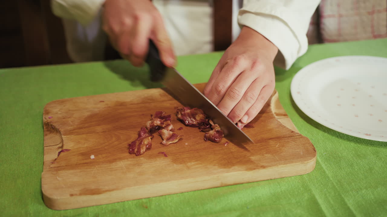 Hands Of A Chef Cooking At Home Cuts Speck On Wooden Chopping Board