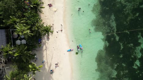 Paradise-Beach-Bohol-Alona-Beach-Philippinen-Topshot-Mit-Palmen-Und-Touristen,-Die-Sich-Am-Strand-Entspannen-Und-Spielen