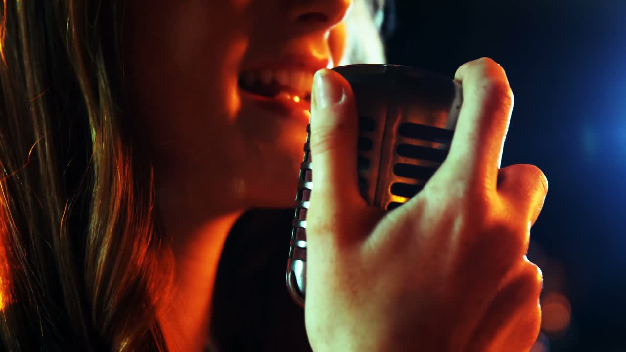 스튜디오에서 노래하는 여성 가수의 클로즈업