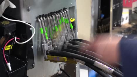 trabajador de fábrica instalando mangueras de presión en un dispensador de soda