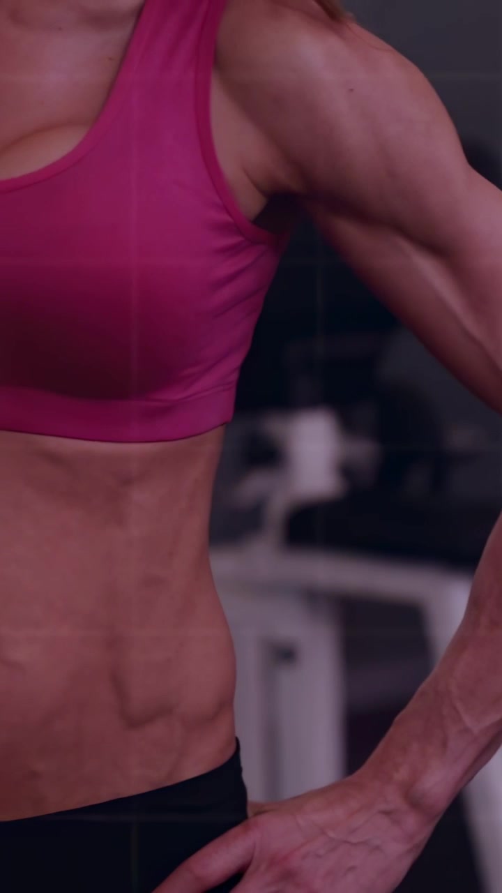 Video verticale: La telecamera si sposta al centro su una donna che flette il braccio per visualizzare metriche di fitness, con grafici sovrapposti.